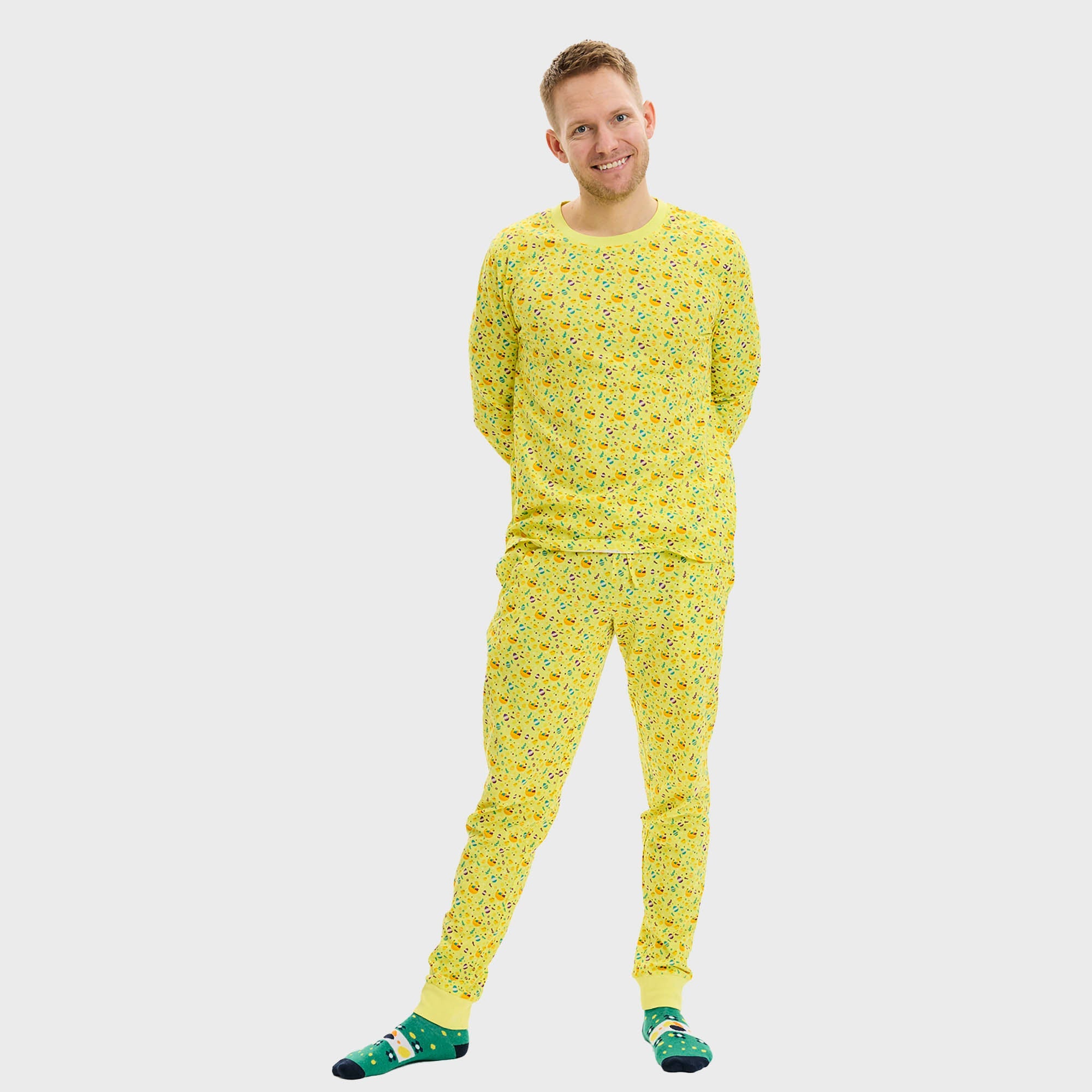 En kvinne og et barn poserer i gul påskepyjamas.